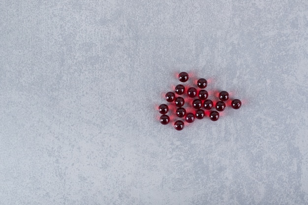 Beaucoup de pilules rouges en cercle sur une surface grise