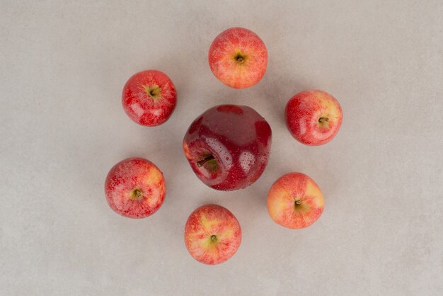 Beaucoup de pommes rouges sur tableau blanc.