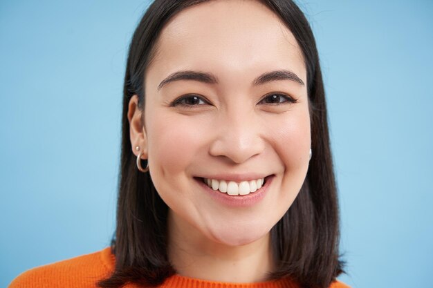 Beauté et bien-être portrait en gros plan d'une jeune femme asiatique heureuse souriante et montrant une émotion franche