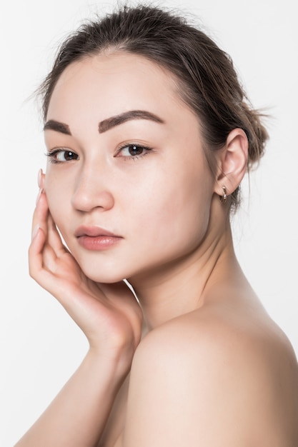 Beauté femme asiatique avec une peau douce et propre isolée sur mur blanc.