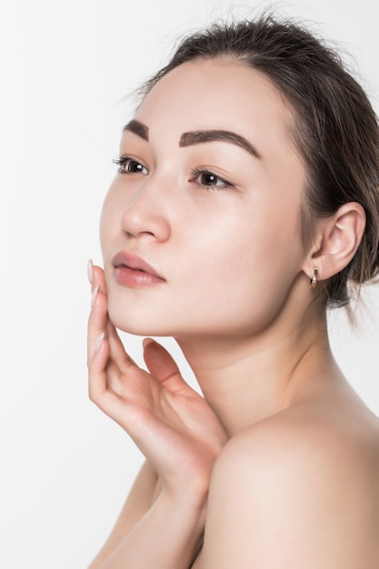 Beauté femme asiatique avec une peau douce et propre isolée sur mur blanc.