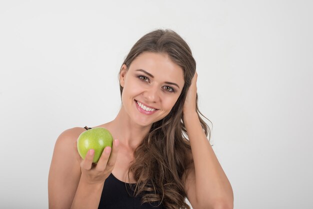 Beauté femme tenant une pomme verte alors qu&#39;elle est isolée sur blanc