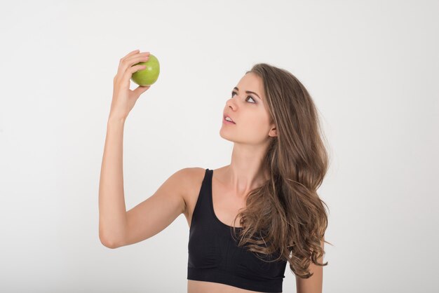 Beauté femme tenant une pomme verte alors qu&#39;elle est isolée sur blanc