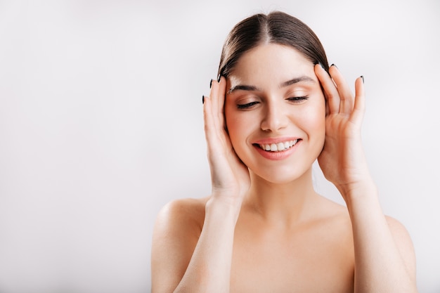 Beauté naturelle. Jeune femme européenne sans maquillage et filtres posant sur un mur isolé.