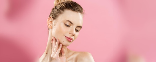 Beauté de la peau Concept Belle jeune femme caucasienne avec une peau propre et fraîche détourner le regard avec fond de studio rose Fille beauté soins du visage Traitement du visage Cosmétologie beauté et spa