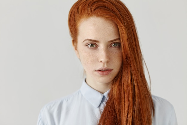 Beauté, soins de la peau et soins capillaires. Superbe jeune femme avec une peau parfaite de taches de rousseur propre portant ses longs cheveux roux lâches sur le côté