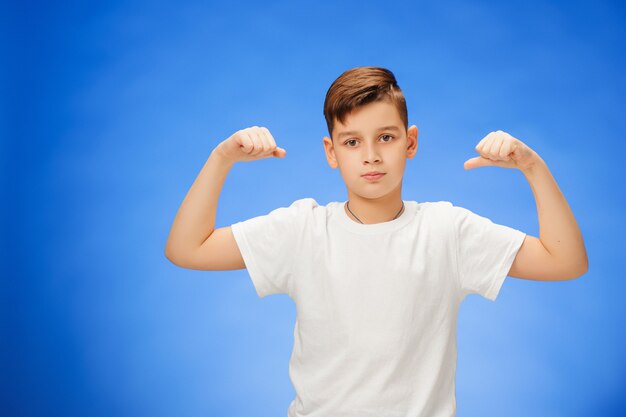 Beauté souriant sport enfant garçon montrant ses biceps