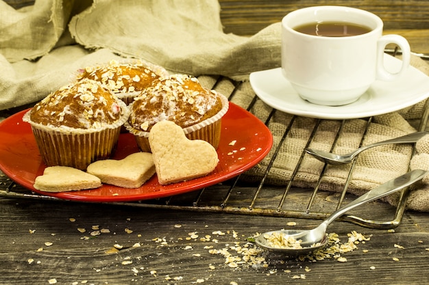 beaux cupcakes aux fruits rouges sur une table en bois en plaque rouge