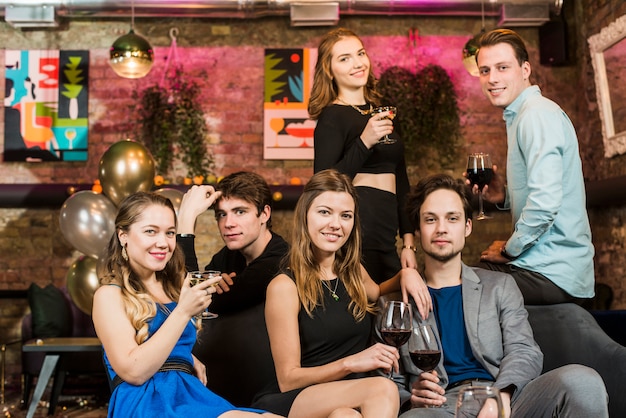 Beaux jeunes couples heureux profitant d&#39;un verre à la fête