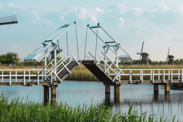 Photo gratuite beaux moulins à vent hollandais traditionnels près des canaux d'eau avec pont-levis