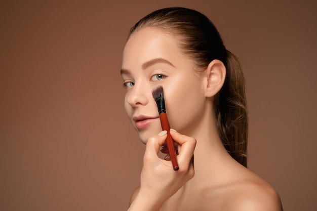 Beaux yeux féminins avec maquillage et pinceau