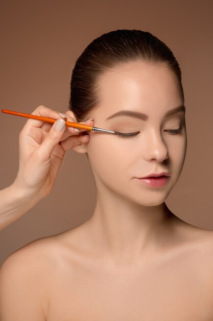 Beaux yeux féminins avec maquillage et pinceau