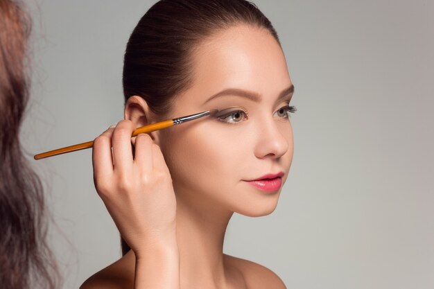 Beaux yeux féminins avec maquillage et pinceau