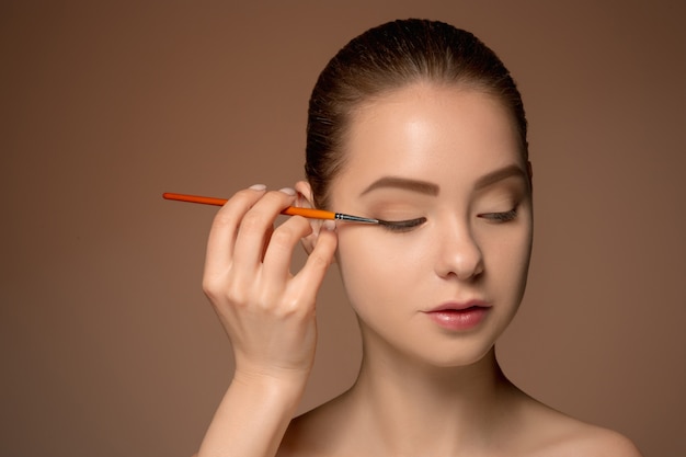 Beaux yeux féminins avec maquillage et pinceau