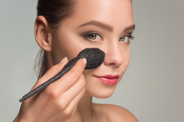 Beaux yeux féminins avec maquillage et pinceau