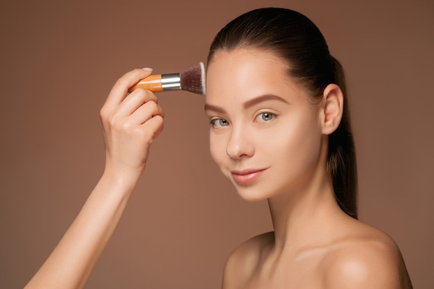 Beaux yeux féminins avec maquillage et pinceau