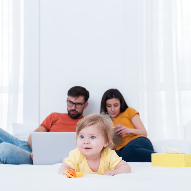 Bébé au lit avec les parents