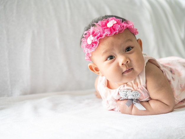 Le bébé est allongé face contre terre sur le lit.