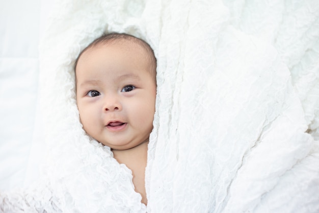 Le bébé est heureux sur le lit.