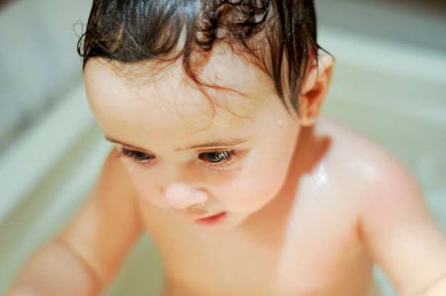 Bébé fille six mois ayant son bain et pleurant