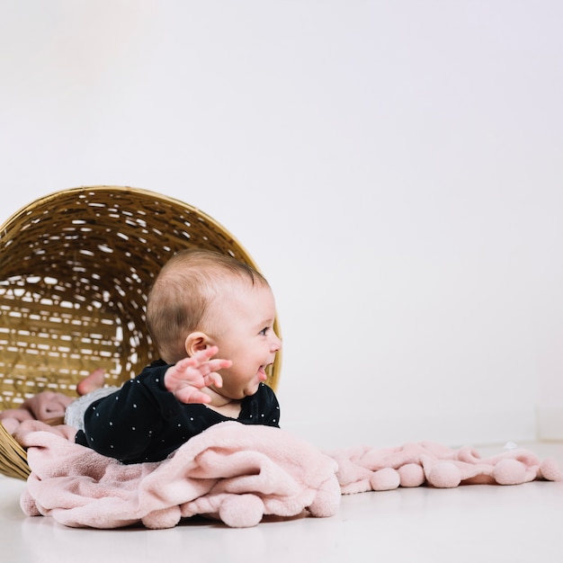 Photo gratuite bébé funny couché dans le panier renversé