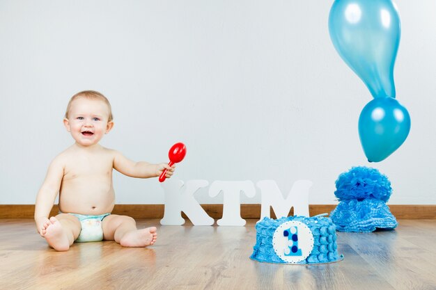 Bébé garçon célébrant son premier anniversaire avec gourmet cake and ba