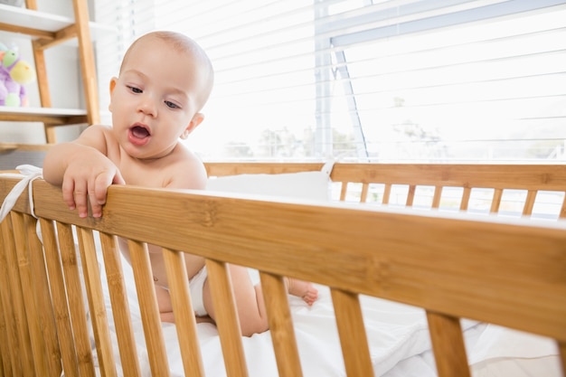 Bébé garçon jouant sur un berceau