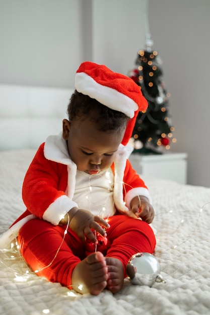 Photo gratuite bébé jouant avec des lumières de noël plein coup