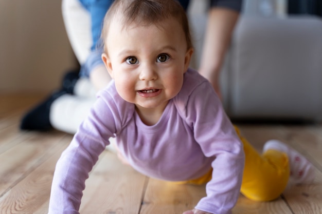 Bébé rampant avec l'aide de sa mère