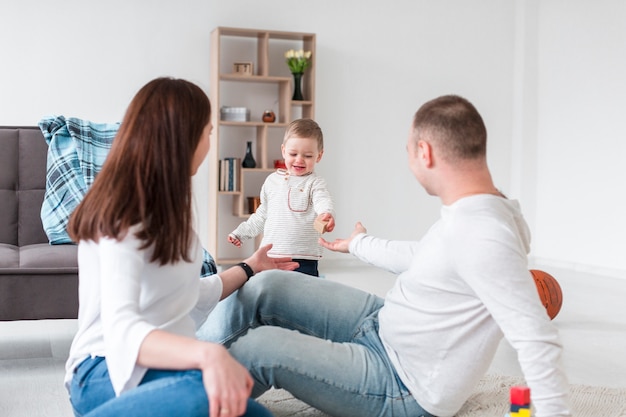 Photo gratuite bébé smiley avec les parents à la maison