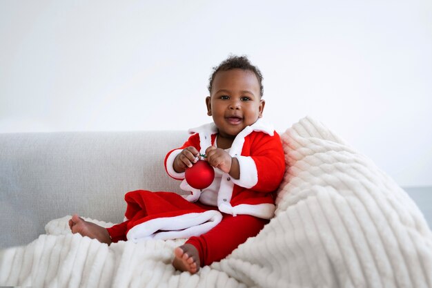 Photo gratuite bébé souriant plein coup portant une tenue de père noël