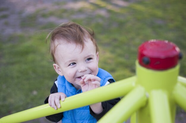 Bébé sourit dans l'aire de jeux d'un parc