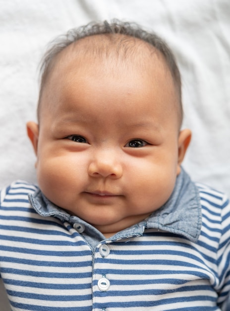 Le bébé sourit joyeusement.