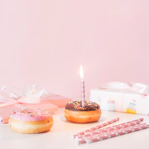 Beignet d&#39;anniversaire vue de face avec bougie allumée