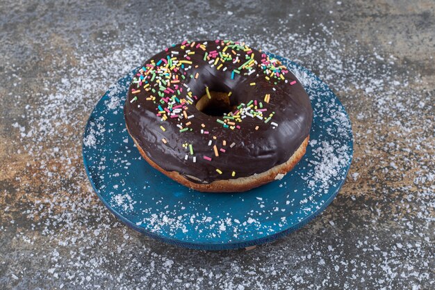 Beignet enrobé de chocolat affiché sur une surface en marbre