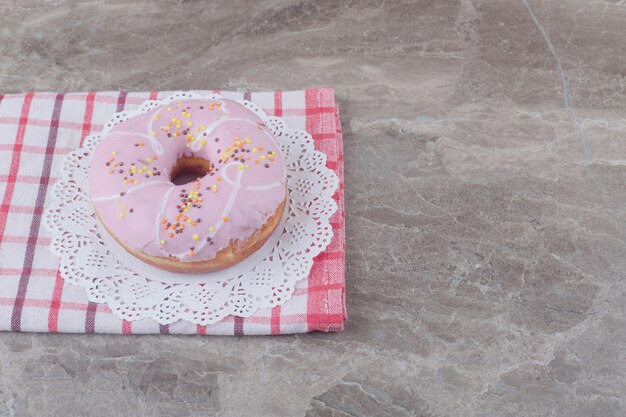 Beignet glacé sur un napperon sur une serviette sur marbre