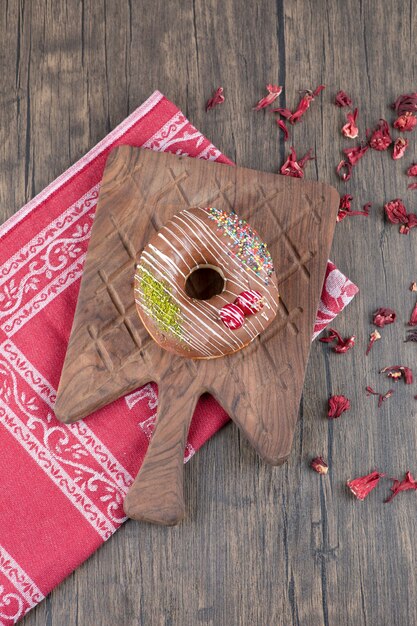 Beignets au chocolat sur planche de bois avec des pétales de rose séchées.