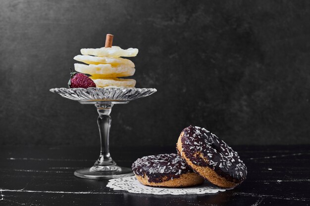 Beignets au chocolat avec des tranches d'ananas séchées dans un plateau en verre.