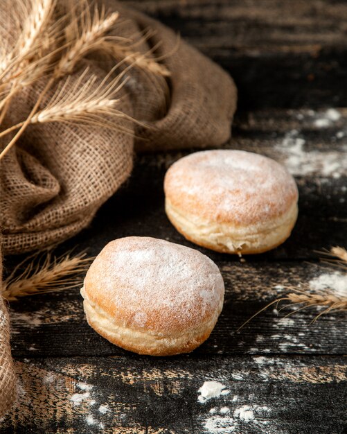 beignets fourrés à la crème avec de la crème au beurre et du sucre en poudre sur la table