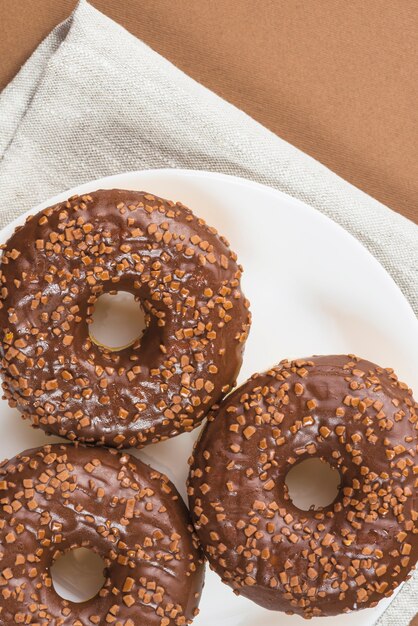 Beignets frais enrobés de chocolat et saupoudrés sur une assiette