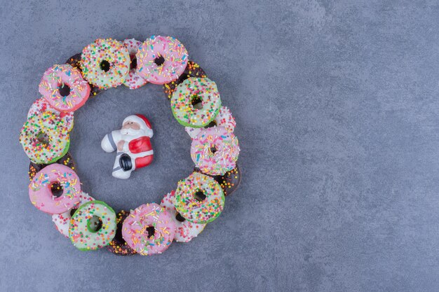 Beignets frais sucrés colorés sur une surface grise