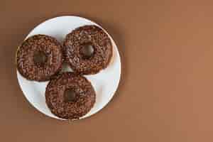 Photo gratuite beignets glacés au chocolat sur plaque blanche