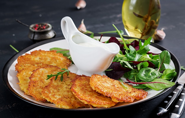 Beignets de pommes de terre servis avec de la crème sure