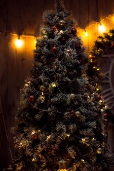 Bel arbre de noël décoré dans le noir à la maison. nouvel an, concept de vacances