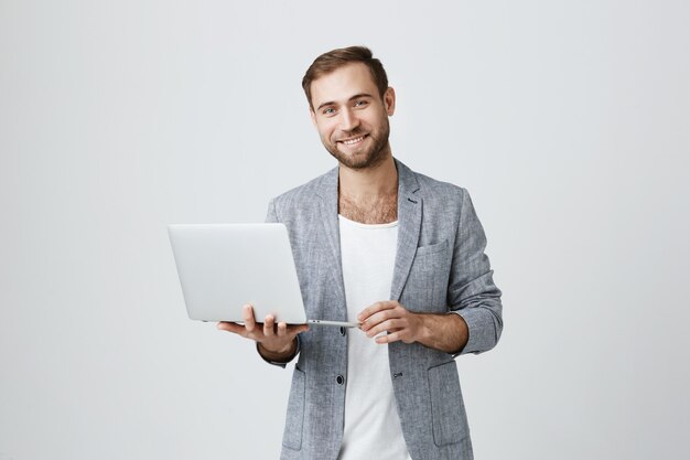 Un bel entrepreneur qui utilise un ordinateur portable
