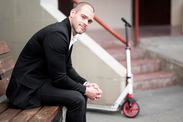 Photo gratuite bel homme d'affaires, assis sur un banc