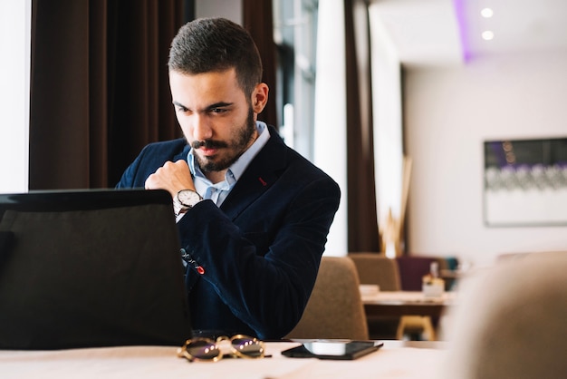 Bel homme d&#39;affaires avec ordinateur portable à table