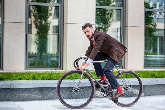 Photo gratuite bel homme d'affaires et son vélo