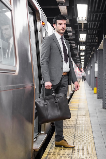 Photo gratuite bel homme d'affaires, sortir de la voiture de métro