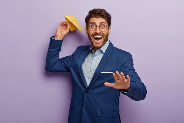 Bel homme d'affaires souriant heureux posant en costume chic au bureau